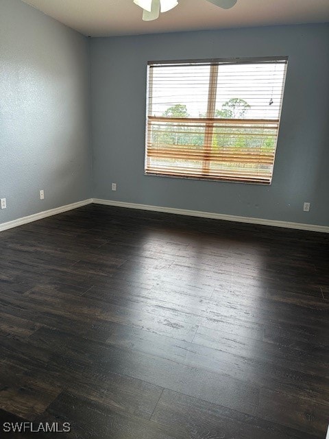 empty room with ceiling fan and dark wood-type flooring