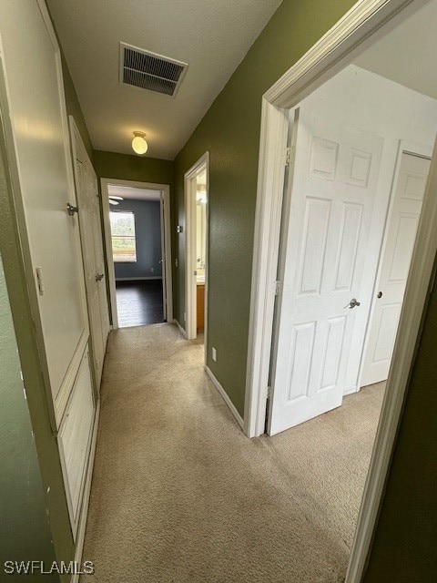 corridor featuring light colored carpet