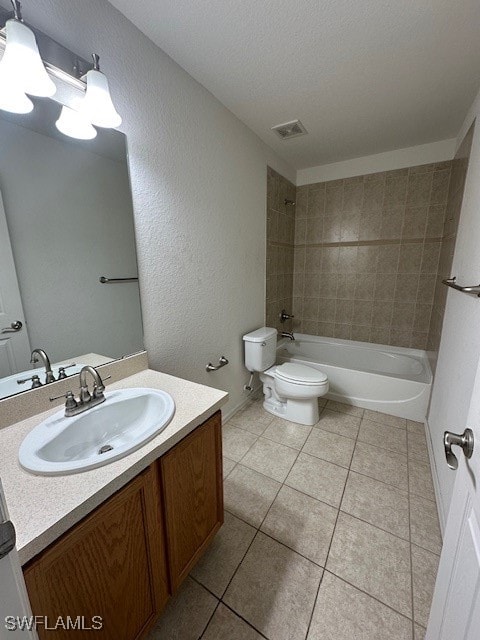 full bathroom with vanity, tiled shower / bath, tile patterned flooring, toilet, and a textured ceiling