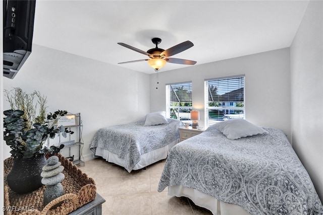 tiled bedroom featuring ceiling fan