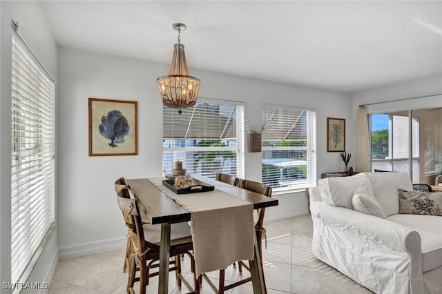 dining area with light tile patterned flooring and a notable chandelier