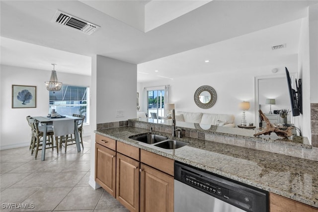 kitchen featuring pendant lighting, sink, a notable chandelier, light stone countertops, and stainless steel dishwasher