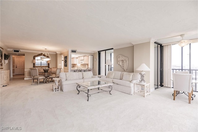 carpeted living room with ornamental molding and ceiling fan