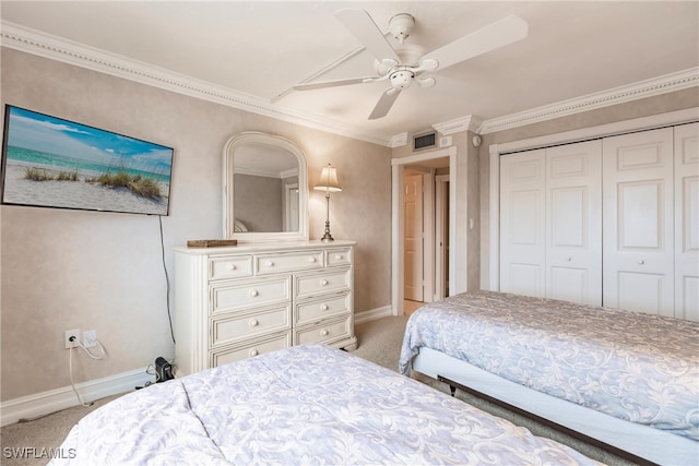 carpeted bedroom with ceiling fan, crown molding, and a closet