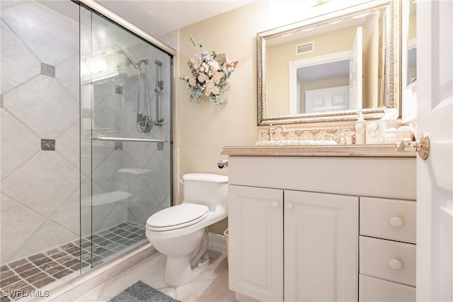 bathroom with toilet, vanity, an enclosed shower, and tile patterned flooring