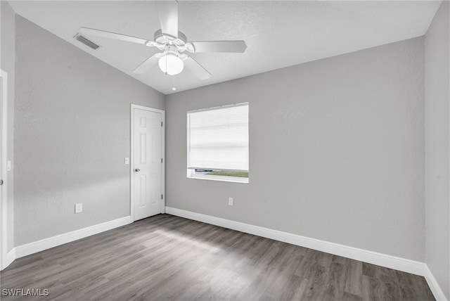 empty room featuring wood-type flooring, ceiling fan, and vaulted ceiling