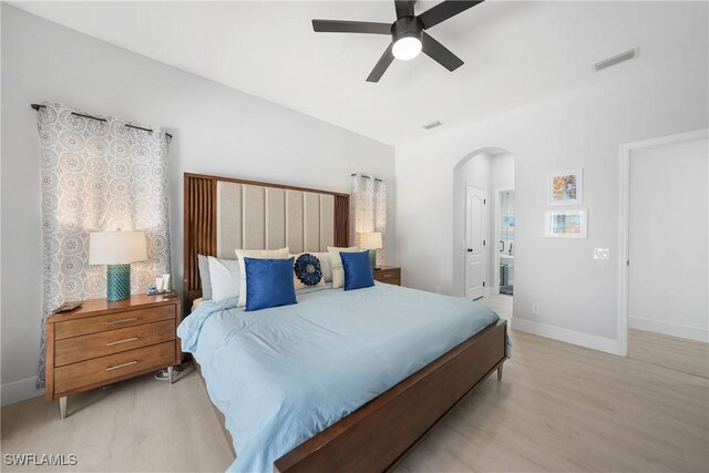 2532 Blackburn Cir, Cape Coral, FL 33991 - bedroom featuring arched walkways, light wood-style floors, baseboards, and ensuite bathroom
