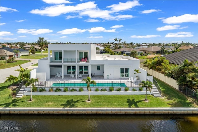 rear view of property featuring a fenced in pool, a water view, a balcony, a yard, and a patio area