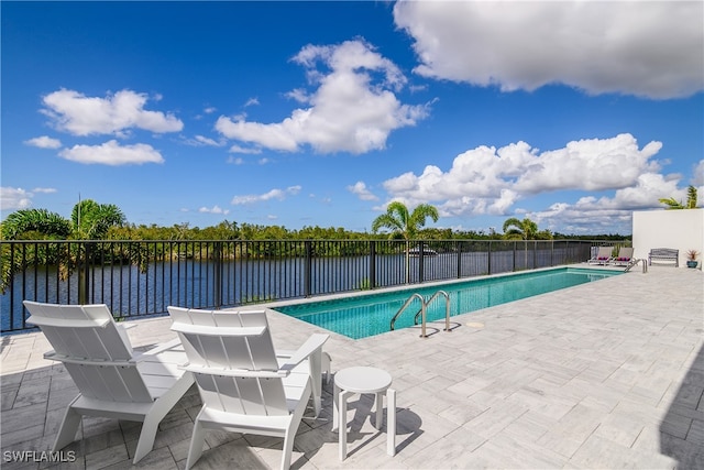 view of swimming pool with a patio area and a water view