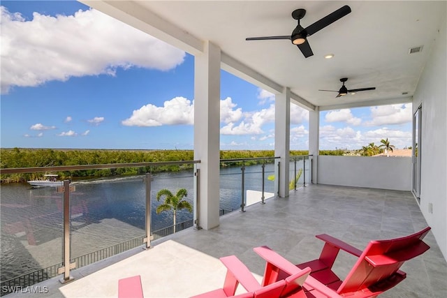 view of patio / terrace featuring a water view, ceiling fan, and a balcony