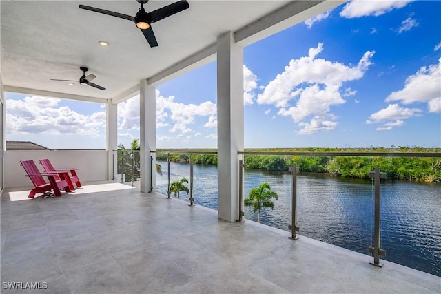 view of patio featuring a water view and ceiling fan