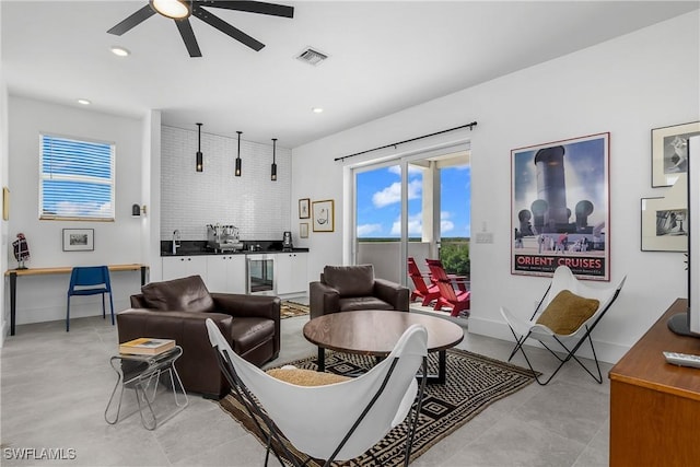 living room with ceiling fan, sink, and beverage cooler