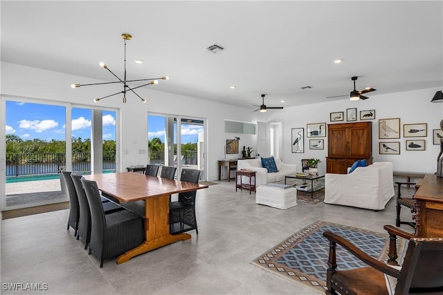 dining space featuring ceiling fan with notable chandelier