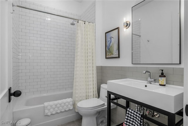 bathroom with toilet, shower / tub combo with curtain, and tile walls