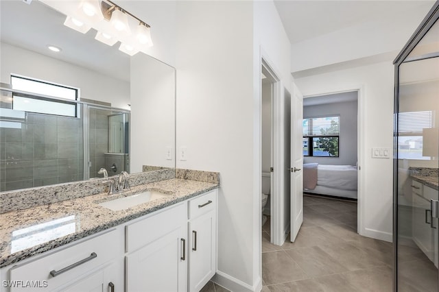 bathroom with a wealth of natural light, a shower with door, vanity, and toilet