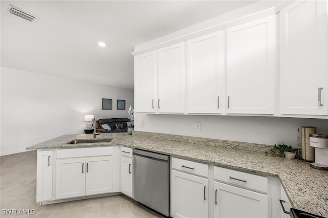 kitchen with white cabinets, sink, stainless steel dishwasher, light stone counters, and kitchen peninsula