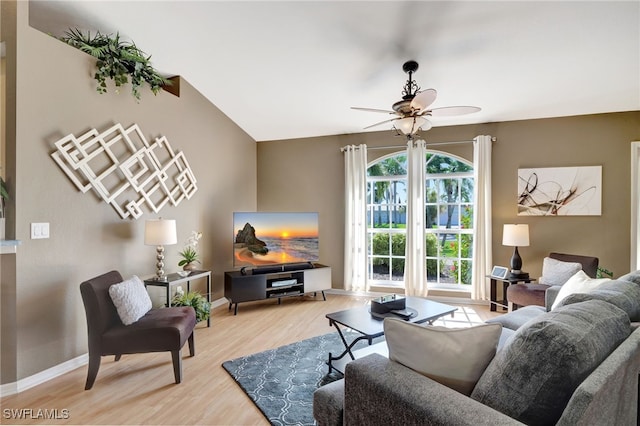 living room with ceiling fan, vaulted ceiling, and light wood-type flooring