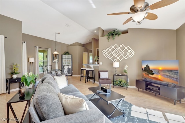 living room with ceiling fan, light hardwood / wood-style flooring, and lofted ceiling