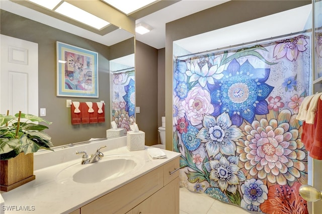 bathroom featuring toilet, vanity, a shower with curtain, and tile patterned flooring