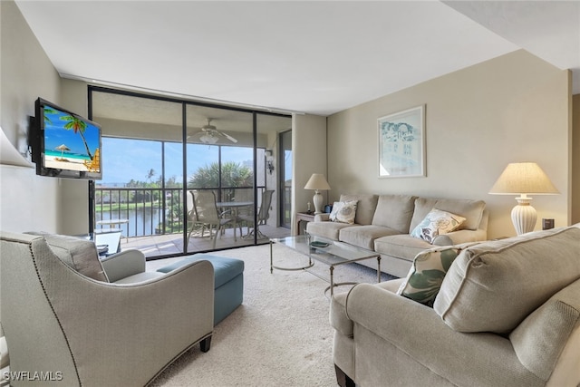 carpeted living room with a wall of windows and ceiling fan