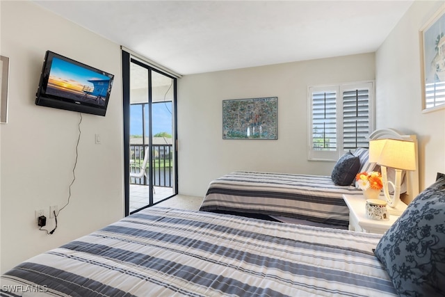 carpeted bedroom featuring access to exterior, floor to ceiling windows, and multiple windows