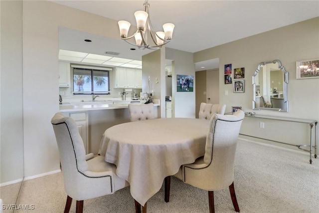 dining space with light colored carpet, a notable chandelier, and baseboards