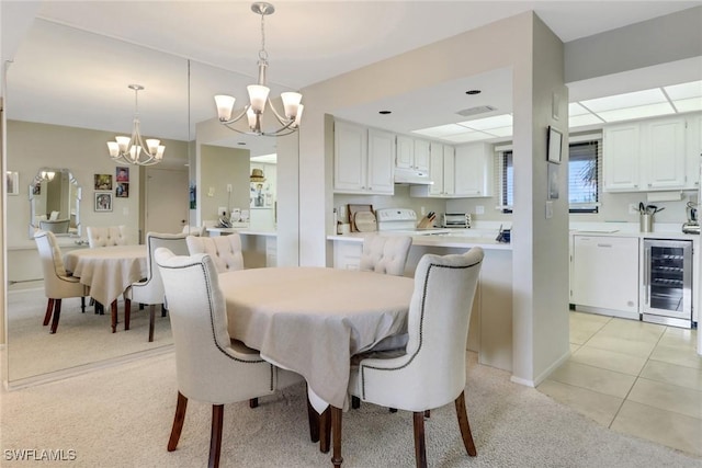 dining space featuring a chandelier, beverage cooler, and light tile patterned flooring