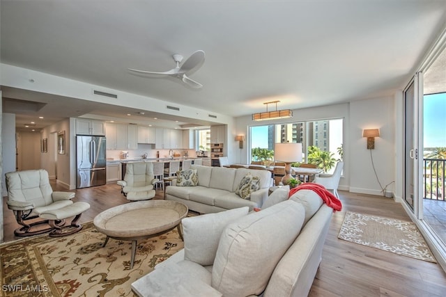 living room with ceiling fan and light hardwood / wood-style floors