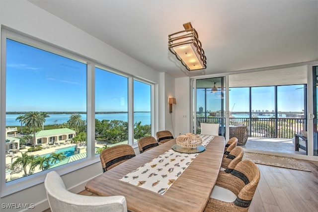 dining room featuring hardwood / wood-style floors and a water view