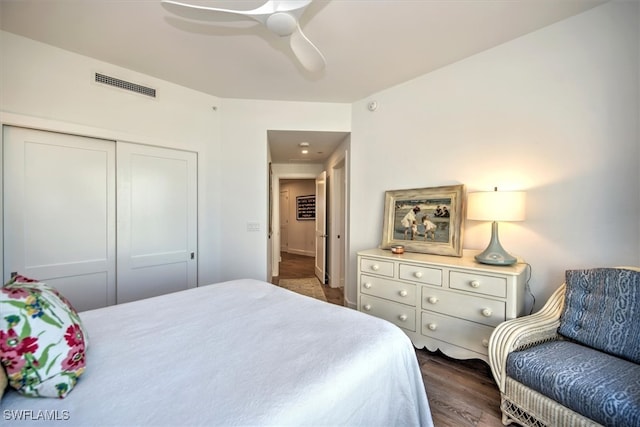 bedroom with dark wood-type flooring, a closet, and ceiling fan