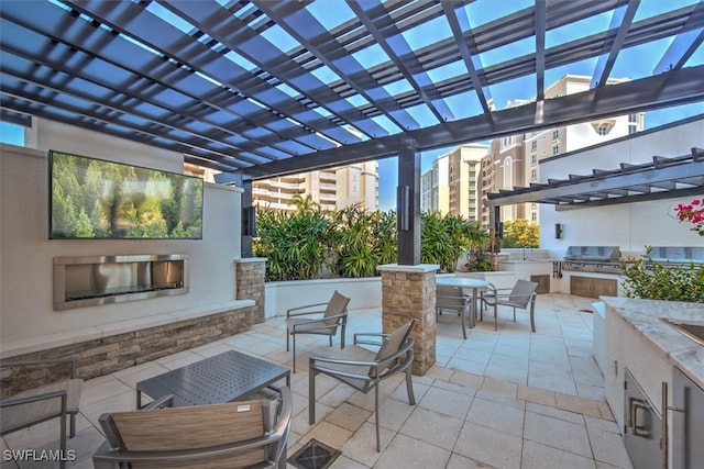 view of patio / terrace with area for grilling, an outdoor wet bar, and a pergola