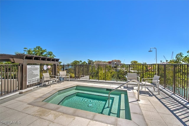 view of swimming pool featuring a hot tub and a patio area