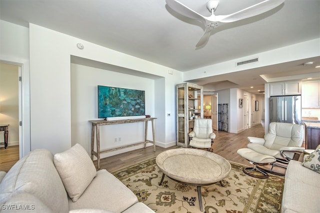 living room with wood-type flooring and ceiling fan