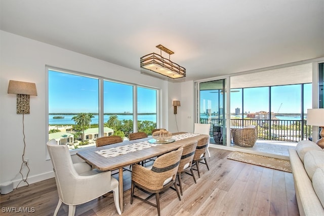 dining area featuring hardwood / wood-style floors and a water view