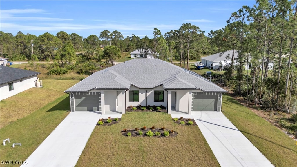 view of front of home with a garage and a front lawn