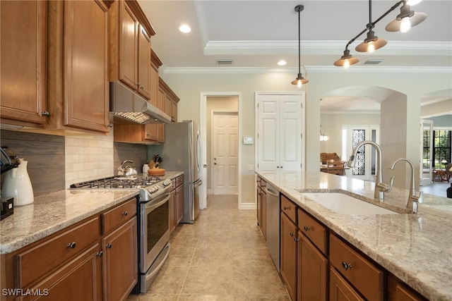 kitchen featuring ornamental molding, sink, pendant lighting, and appliances with stainless steel finishes