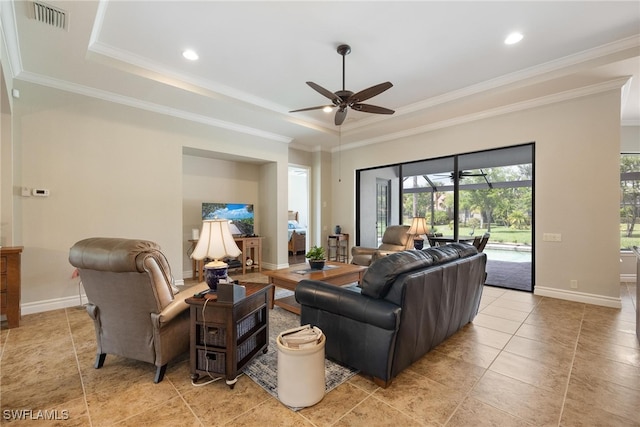 living room with a tray ceiling, ceiling fan, and ornamental molding