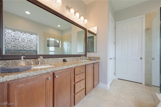 bathroom featuring tile patterned floors, vanity, and a tile shower