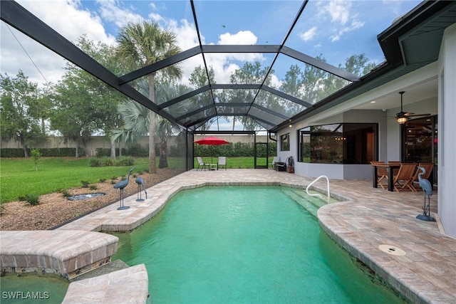 view of swimming pool with a patio, ceiling fan, a lanai, and a lawn