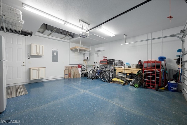 garage featuring an AC wall unit, electric panel, stainless steel fridge, and a garage door opener