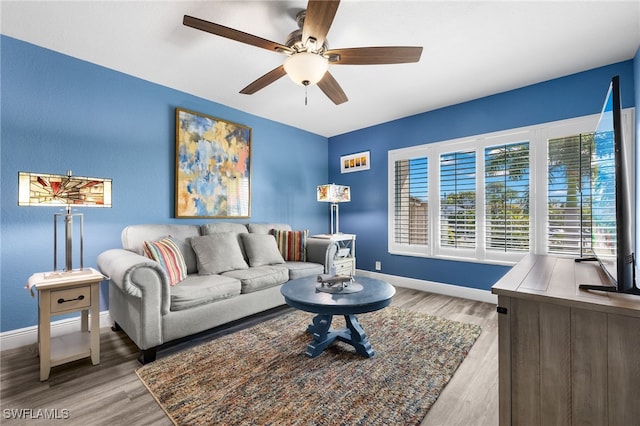 living room featuring light hardwood / wood-style flooring and ceiling fan