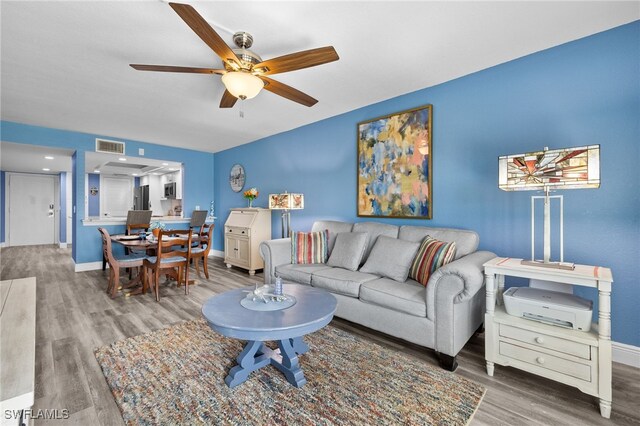 living room with hardwood / wood-style floors and ceiling fan