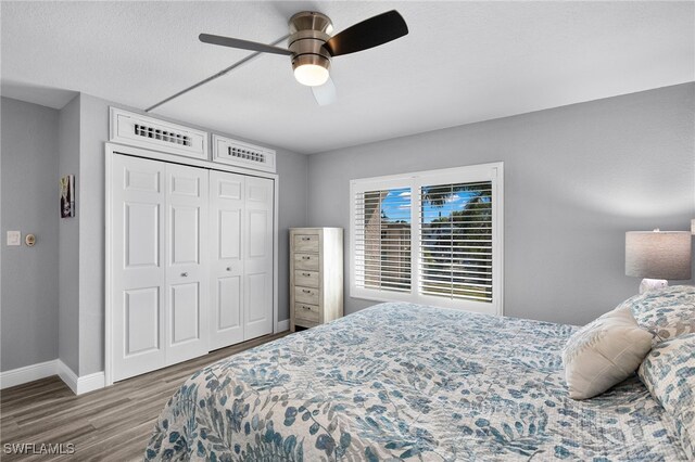 bedroom with ceiling fan, a closet, and wood-type flooring