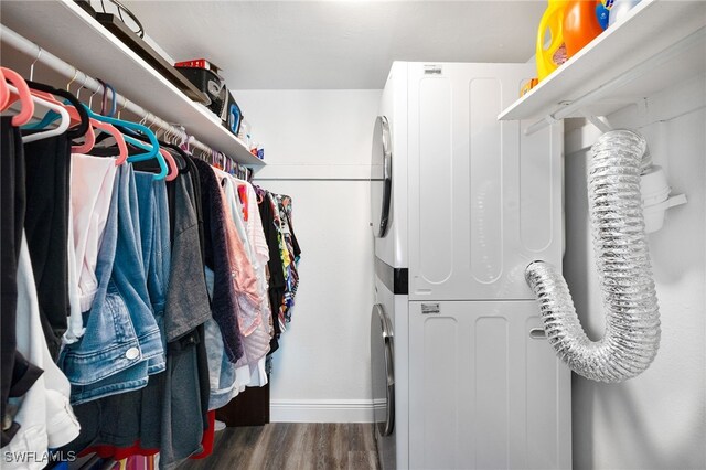 spacious closet with dark hardwood / wood-style flooring and stacked washer and clothes dryer