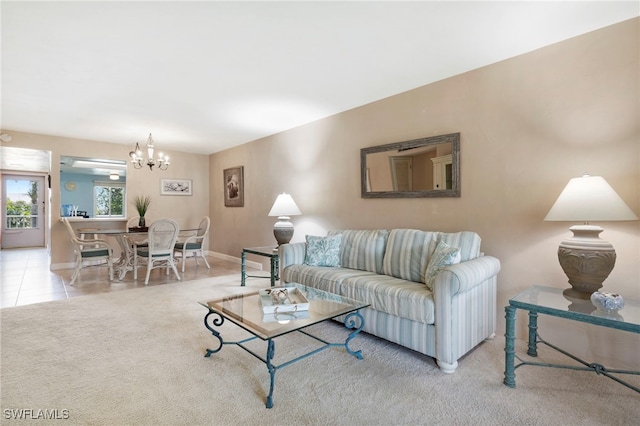 living area featuring a chandelier, light carpet, baseboards, and light tile patterned flooring