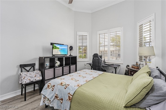 bedroom featuring light hardwood / wood-style floors, ceiling fan, and crown molding