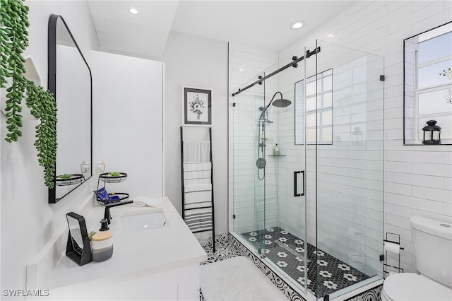 bathroom featuring vanity, toilet, and a shower with door