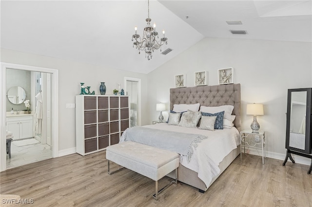 bedroom with sink, a notable chandelier, ensuite bathroom, hardwood / wood-style floors, and lofted ceiling