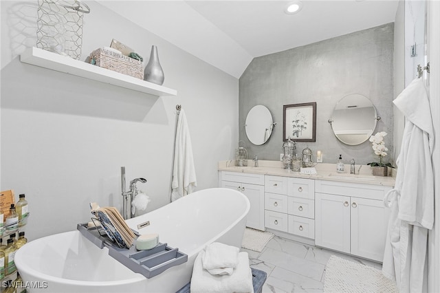 bathroom featuring vanity, a tub, and vaulted ceiling