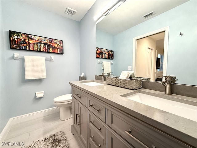 bathroom with tile patterned flooring, vanity, and toilet